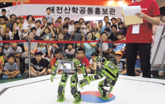 지난해 열린 '지능형 시스템온칩(SoC) 로봇워' 태권로봇 부문에 출전한 로봇들이 서로 공격을 하며 겨루고 있다.    KAIST 제공